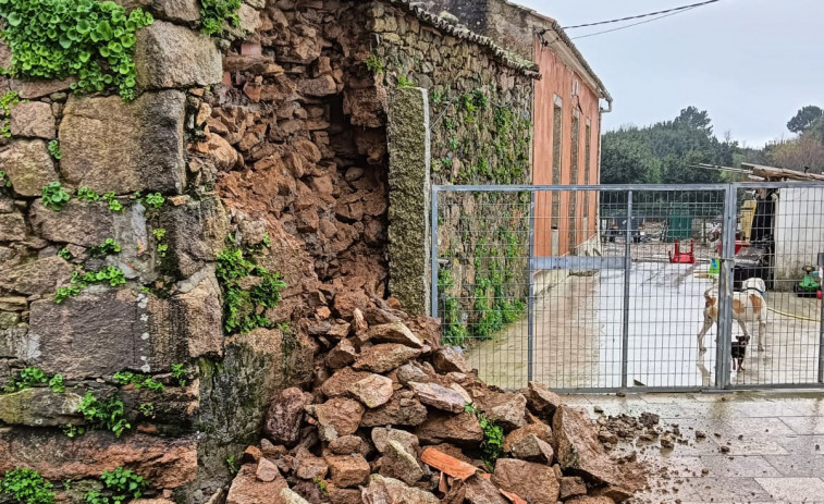 La borrasca Karlotta causa el derrumbe de un muro de una casa antigua en el lugar de Cercias, en A Pobra